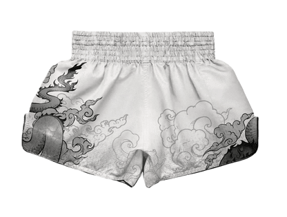 Back view of ARAYKO white Muay Thai shorts showing the wrap-around grey dragon and cloud design. The wide elastic waistband and high-quality fabric texture are highlighted for professional kickboxing use.