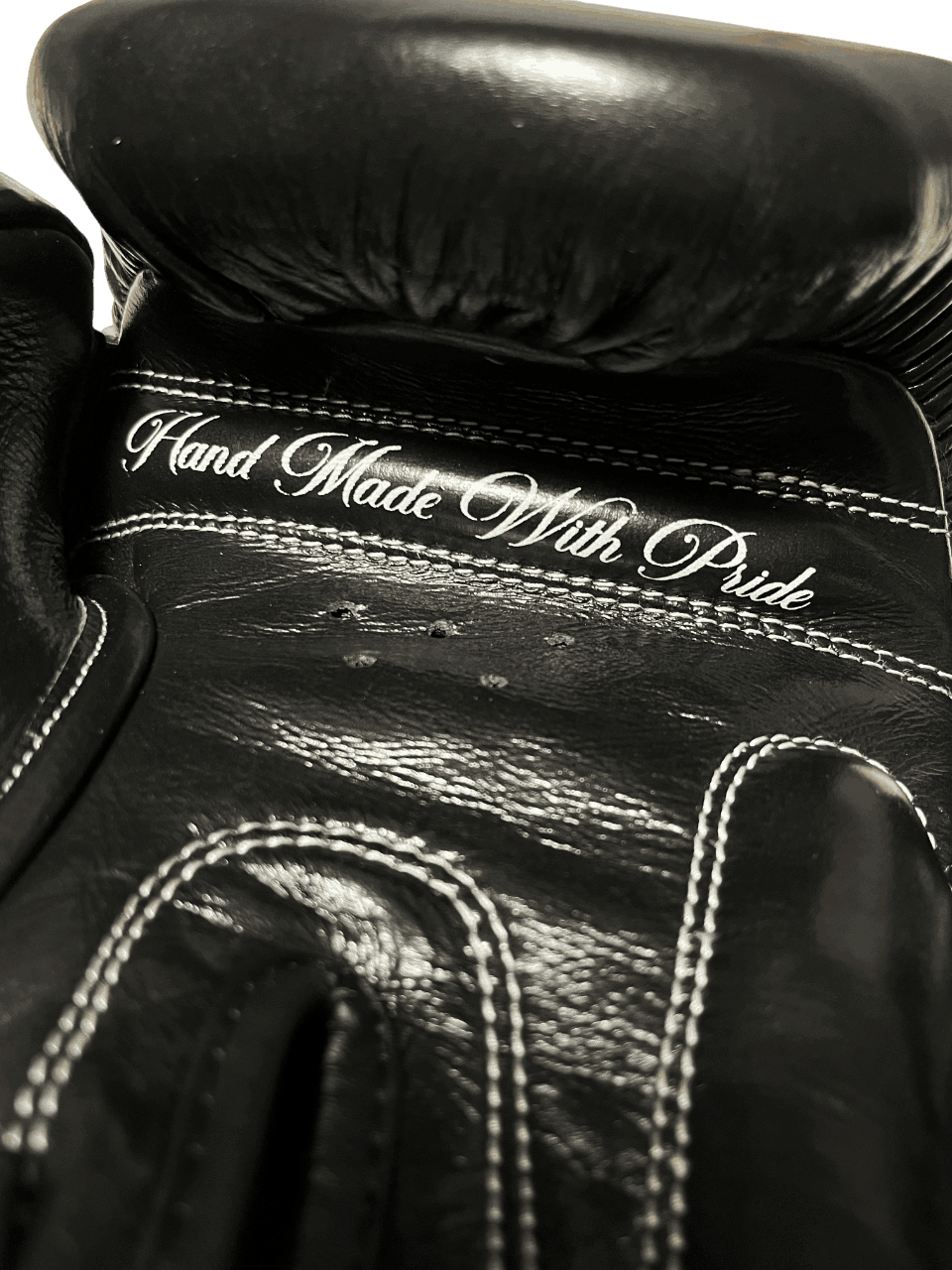 Black Muay Thai glove with 'Hand Made With Pride' embroidery and five air vents on the palm