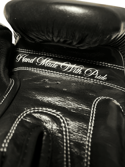 Black Muay Thai glove with 'Hand Made With Pride' embroidery and five air vents on the palm
