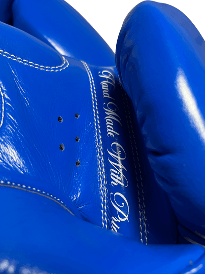 Royal Blue Muay Thai gloves with 'Hand Made With Pride' text on the palm, genuine leather and durable construction