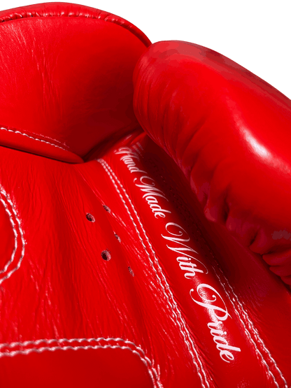 Palm side of Muay Thai glove showing cursive 'Hand Made With Pride' text, highlighting handcrafted quality and detail